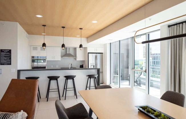 A modern kitchen with a bar area and a dining table.