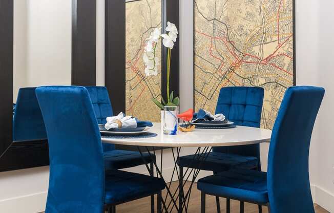 a dining room with a table with blue chairs and a map on the wall
