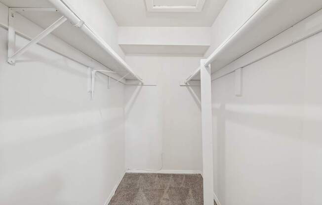 A white hallway with a carpeted floor and white walls.