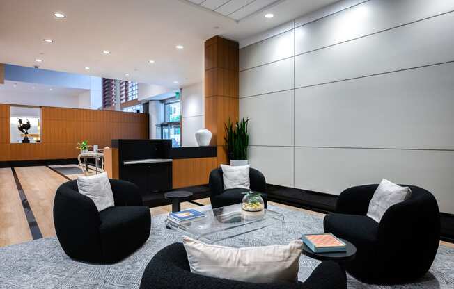 a living room with black chairs and a glass coffee table