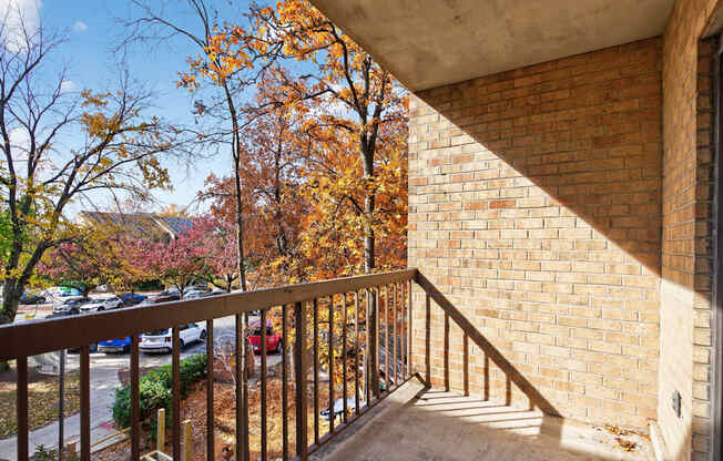 A balcony with a metal railing and a brick wall.