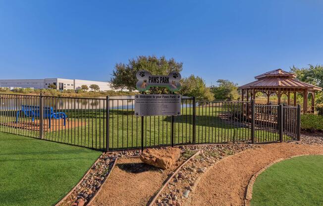 a large green field with trees in the background