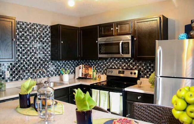 a kitchen with black cabinets and stainless steel appliances