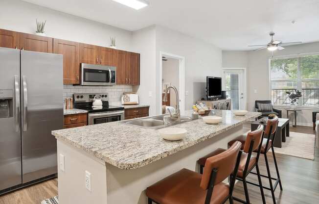 an open kitchen and living room with a granite counter top