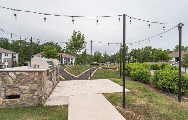 the view of a concrete walkway with lights hanging above it