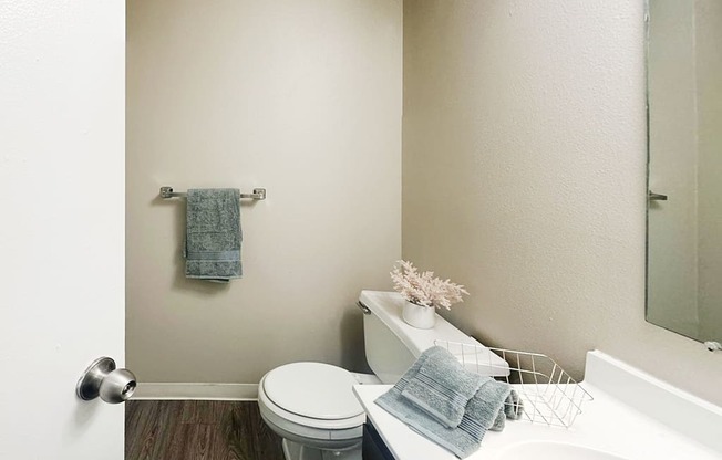 A white toilet sits next to a white sink in a bathroom.