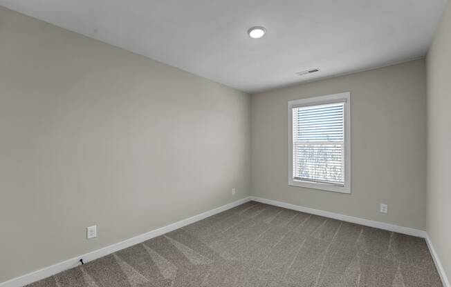 an empty room with white walls and a window