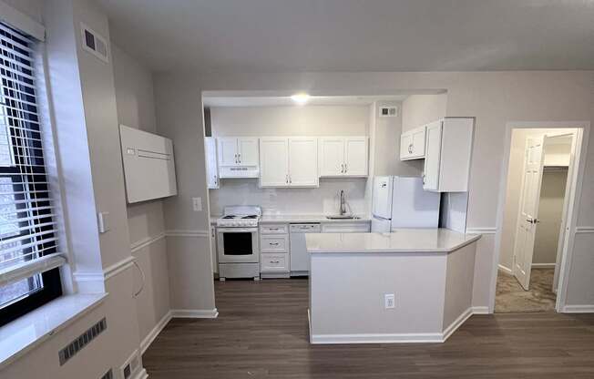 A kitchen with white appliances and cabinets.