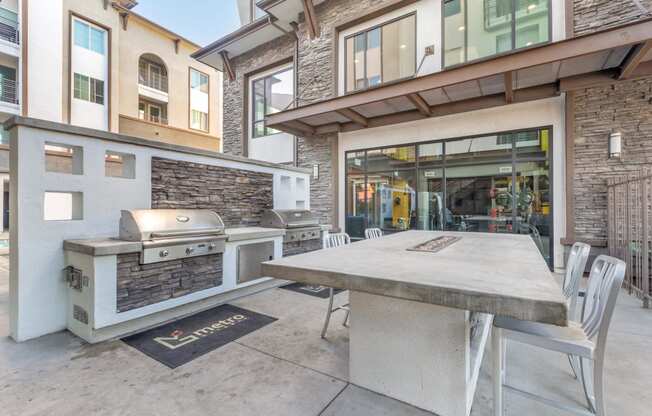 a patio with a table and a grill on the side of a building at Metro Gateway, Riverside, CA, 92503