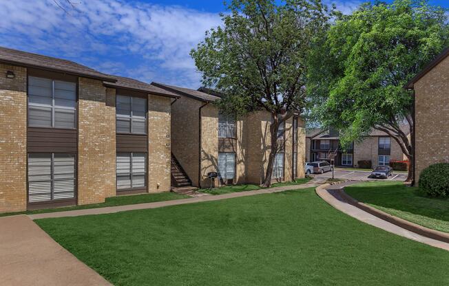 a large lawn in front of a brick building