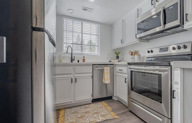 a kitchen with stainless steel appliances and white cabinets  at The Resort at Encinitas Luxury Apartment Homes, Encinitas, 92024