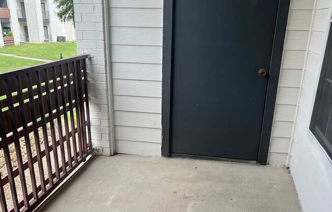 a balcony with a grate and a concrete wall and a window