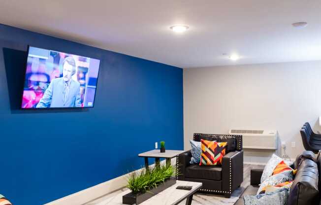 a living room with couches and tables and a tv on the wall