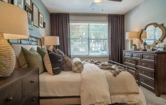 a bedroom with a bed with pillows and a window