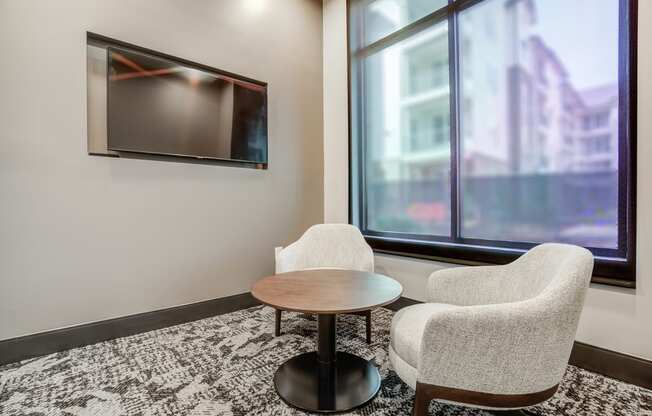 a small table and two chairs in a room with a large window