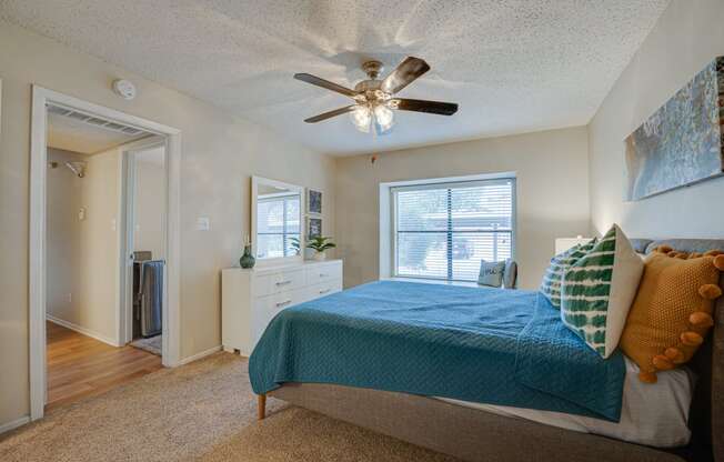 a bedroom with a bed and a ceiling fan