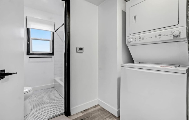 A white washing machine is in a small laundry room.