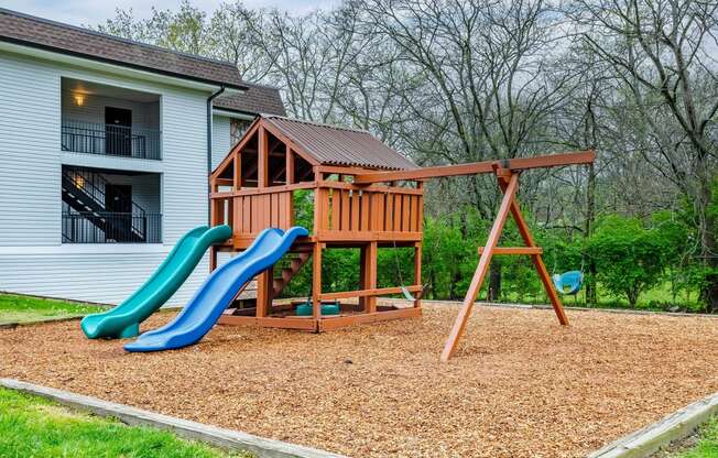 a swing set with a slide in a backyard