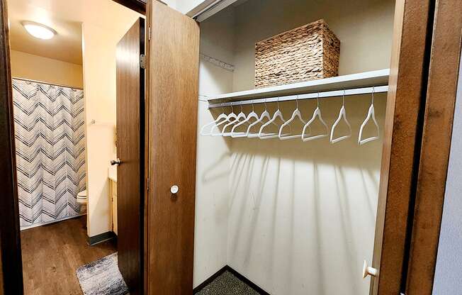 a walk in closet with a rack of wine glasses