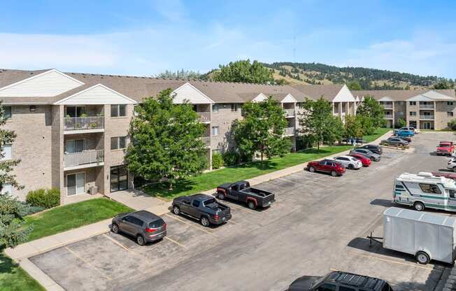 an aerial view of an apartment complex with cars parked in a parking lot