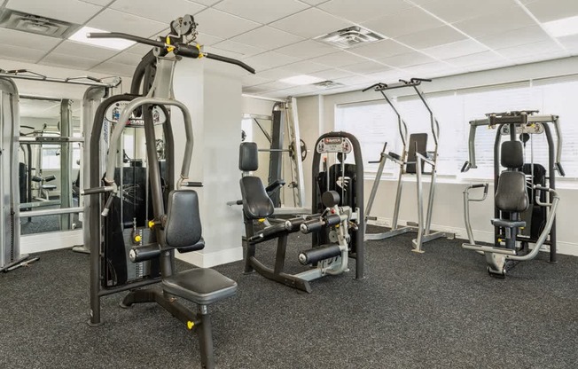 a gym with weights and other equipment in a building at The Lafayette Apartments, Colonial Place, Norfolk