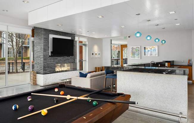 Pool table with a seating area and fireplace in the background