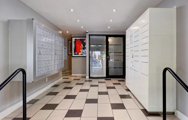 a locker room with white cabinets and a black door