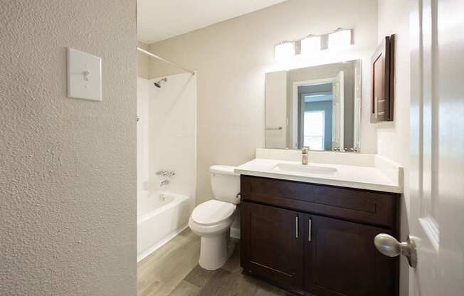 A white sink is in a bathroom with a toilet and a mirror.