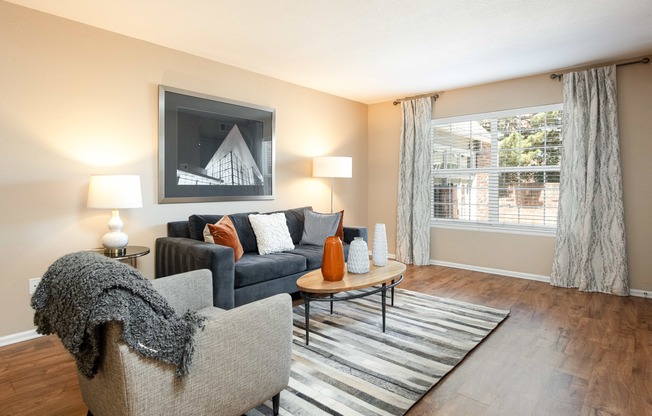 a living room with a couch and a chair and a window