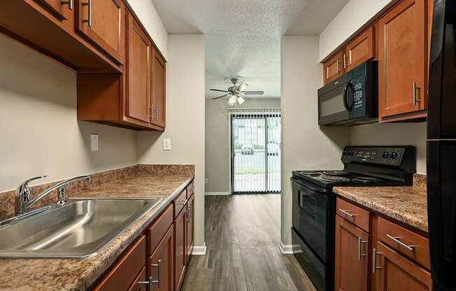 A kitchen with wooden cabinets and a black stove top oven.