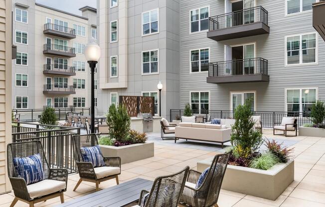 The courtyard at Modera Liberty Row offers stylish seating and greenery, creating a welcoming outdoor escape in the heart of Charlotte.