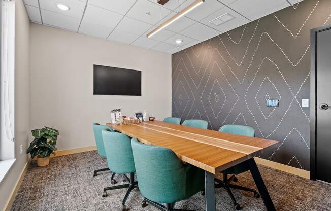 a conference room with a long wooden table and blue chairs at The Lodge at Overland, Rochester, Minnesota