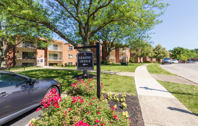 This is photo of the leasing office directional sign and some building exteriorsat Aspen Village Apartments in the Westwood neighborhood of Cincinnati, OH.