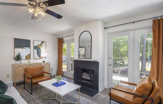 A living room with a fireplace and a ceiling fan.