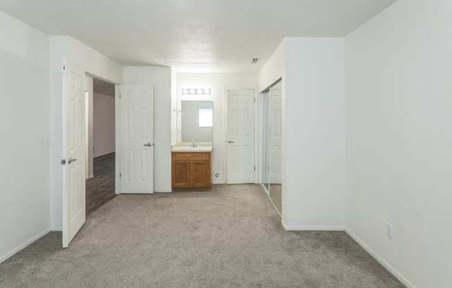 an empty living room with white walls and a bathroom