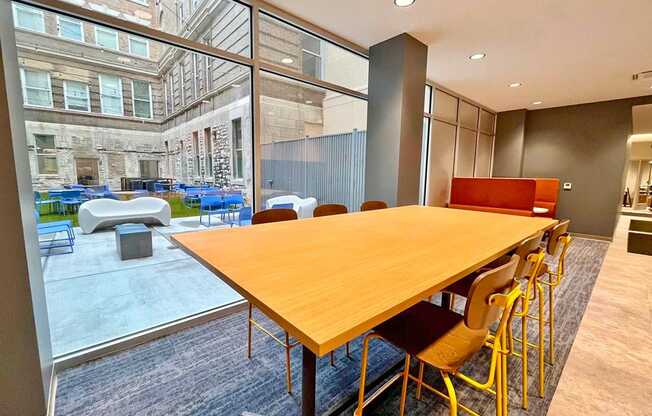 clubroom/resident lounge large work table overlooking courtyard at The Residences at Delmar DivINe, St Louis, MO, 63112