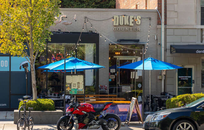 a motorcycle parked in front of a dukes counter on a city street