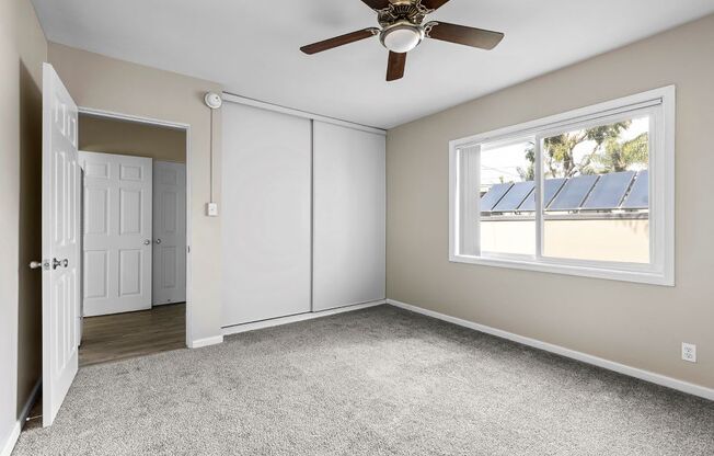 a bedroom with a ceiling fan and a window