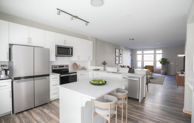 a white kitchen with stainless steel appliances and a white counter top