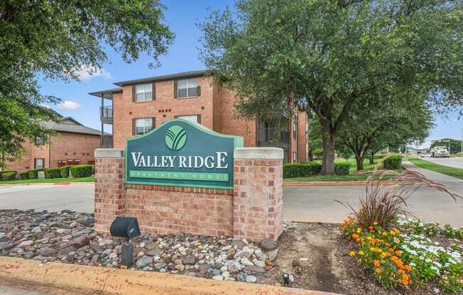 A brick sign that says Valley Ridge in front of a building.