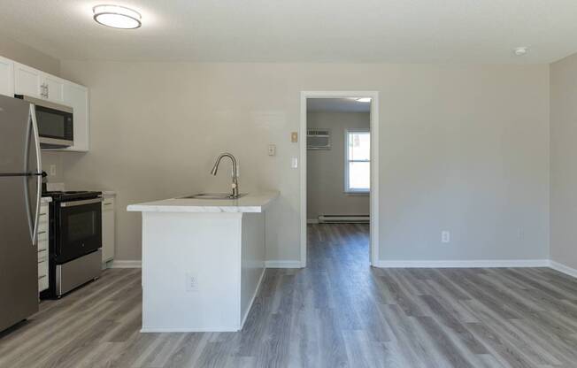 A kitchen with a white island and a refrigerator.