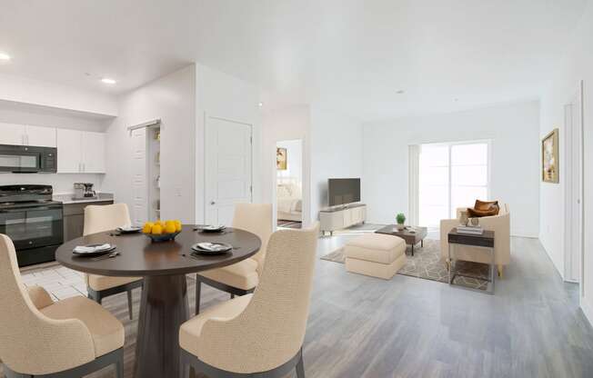 a living room and dining room with white walls and hardwood floors