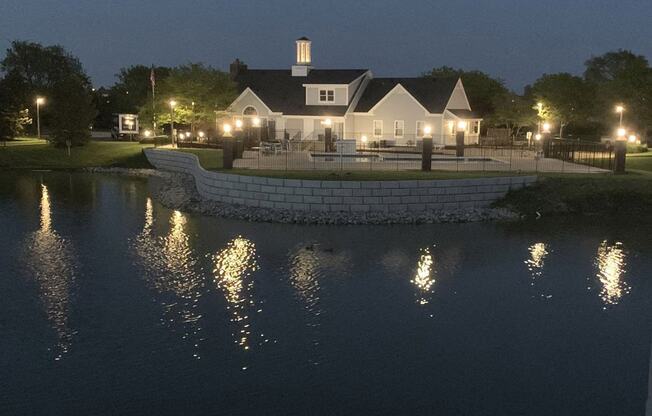 swimming pool and clubhouse at night overlooking as pond at The Crossings Apartments, Michigan