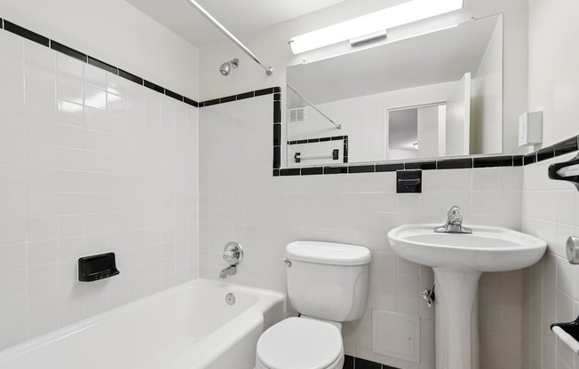 A white bathroom with a tub, toilet, and sink.