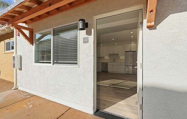 A modern house with a glass door leading to the kitchen.