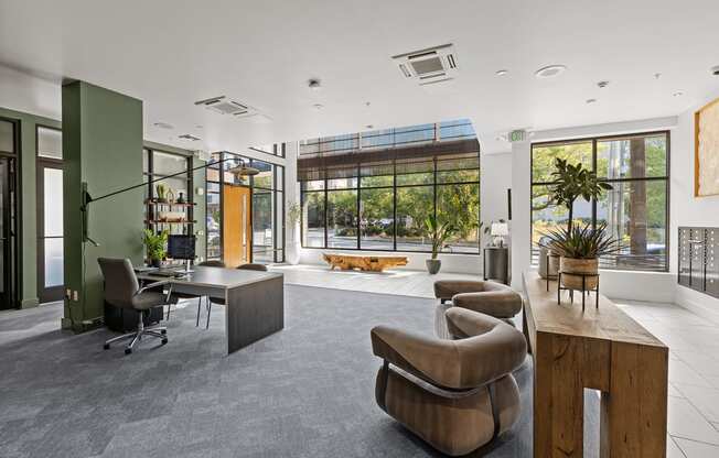 a living room with a desk and chairs and a large window