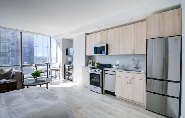 a bedroom with a bed and a kitchen with a refrigerator