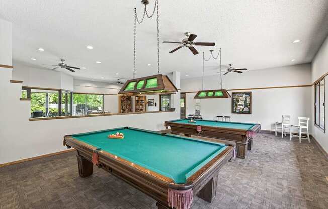 A room with a pool table and a billiard table.
