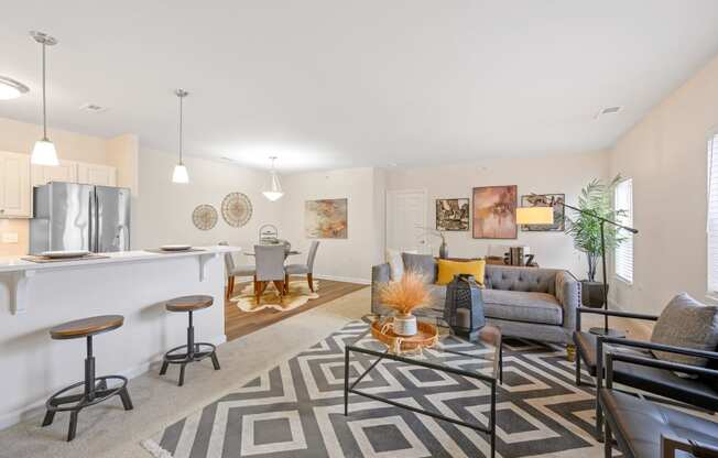 a spacious living room with a kitchenette and dining area