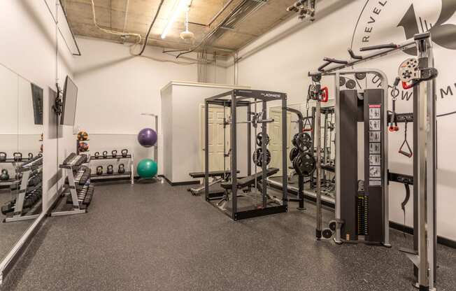 a fully equipped fitness room with weights and cardio equipment